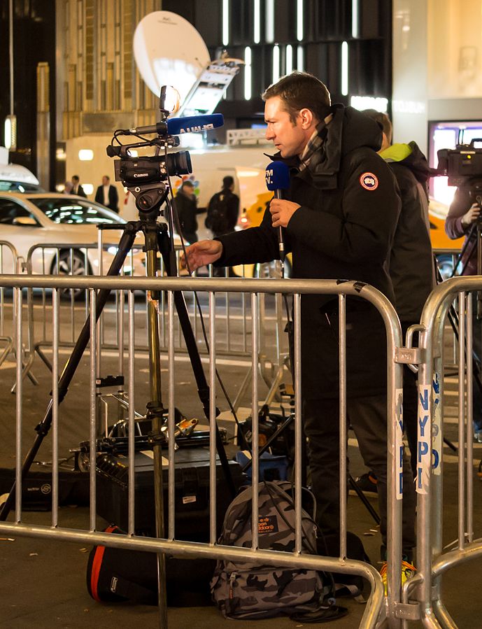 A reporter from BFM TV at the corner of 5th Ave. and 57th St., reporting on the protest against the election of Donald Trump on November 10, 2016. Wikimedia.